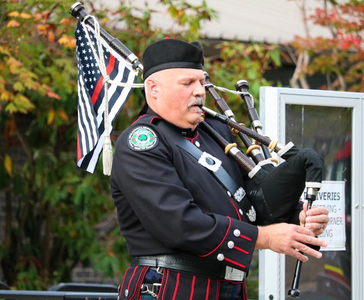 Firefighter and piper playing at City Hall